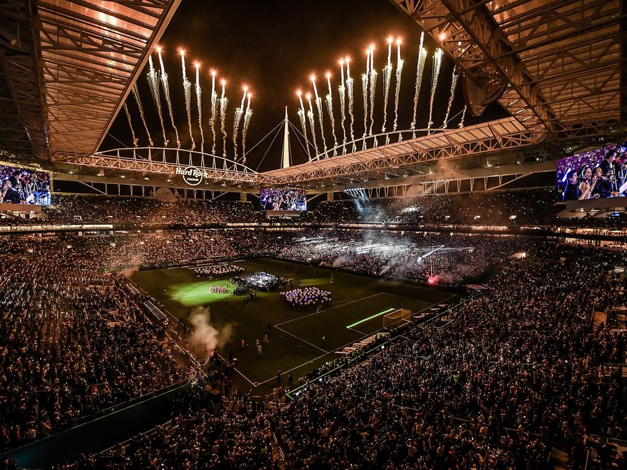 Packed stadium at night with fireworks