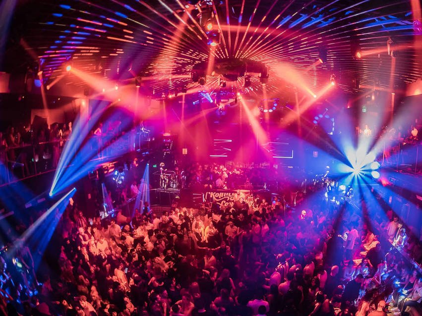 Packed club at night under pink and blue lasers